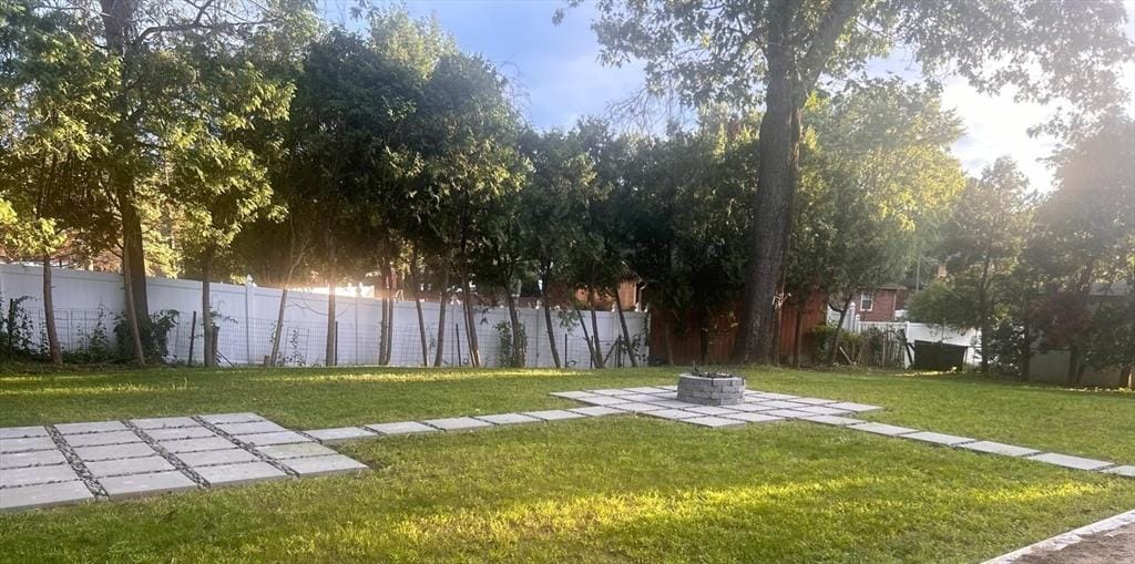 view of yard with a patio, a fenced backyard, and an outdoor fire pit