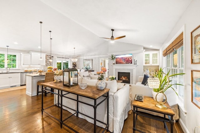 16 Lochmont St, North Attleboro, MA 02760 - living area with wood finished floors, vaulted ceiling, a warm lit fireplace, and a ceiling fan