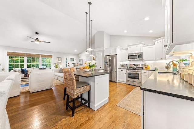 16 Lochmont St, North Attleboro, MA 02760 - kitchen featuring stainless steel appliances, open floor plan, dark countertops, white cabinets, and a breakfast bar