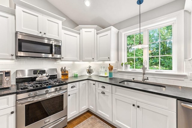 16 Lochmont St, North Attleboro, MA 02760 - kitchen with appliances with stainless steel finishes, white cabinets, decorative backsplash, lofted ceiling, and pendant lighting