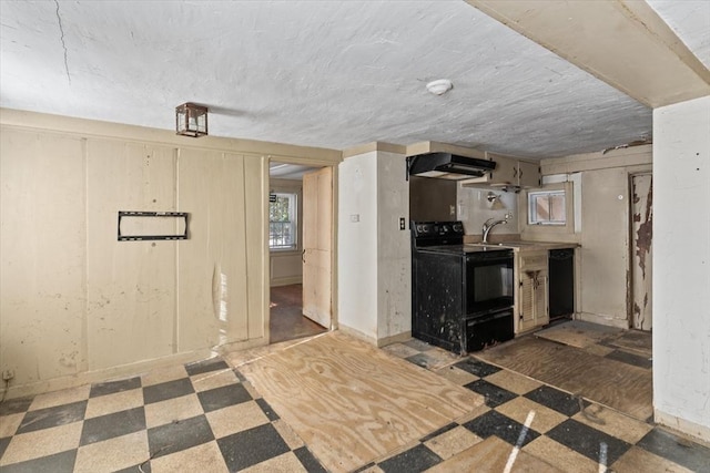 kitchen with under cabinet range hood, a sink, baseboards, tile patterned floors, and black appliances