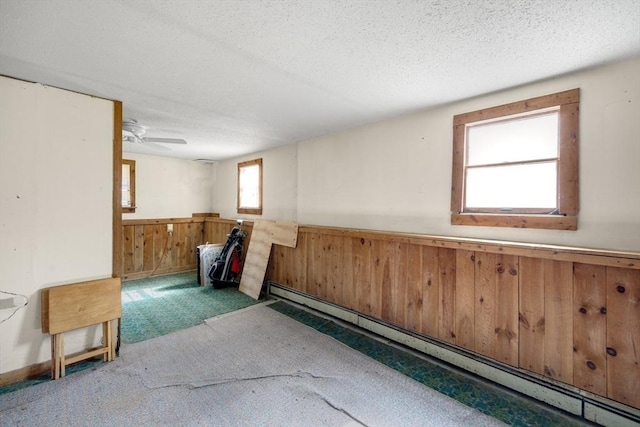 62 Monomoy Cir, Barnstable, MA 02632 - basement featuring a baseboard radiator, wainscoting, carpet floors, wood walls, and a textured ceiling