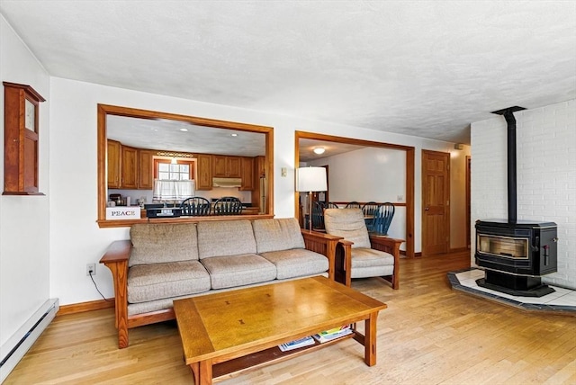 18 Crimson Rd, Billerica, MA 01821 - living area with a baseboard radiator, light wood-style flooring, a wood stove, and baseboards