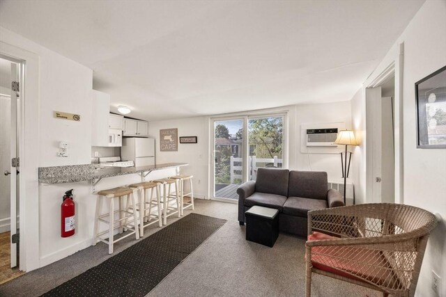 carpeted living room featuring a wall mounted air conditioner