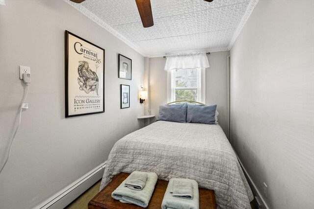 bedroom featuring crown molding, baseboard heating, and ceiling fan