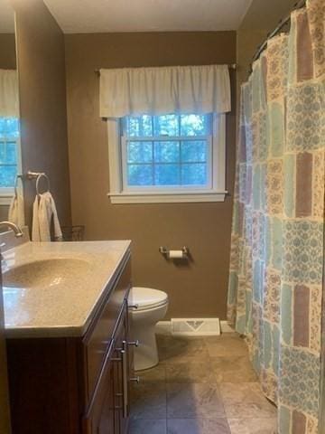 bathroom featuring visible vents, curtained shower, toilet, and vanity