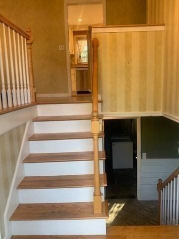 staircase featuring wallpapered walls