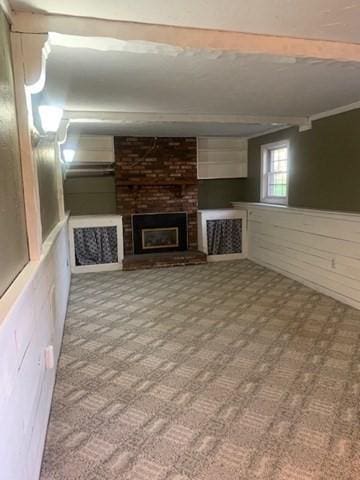 below grade area with a brick fireplace and carpet floors