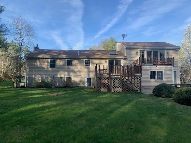rear view of property featuring stairs, a yard, and a wooden deck