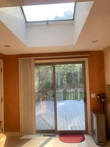 doorway featuring light tile patterned floors and a skylight