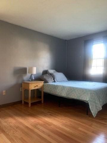 bedroom with light wood-type flooring and baseboards