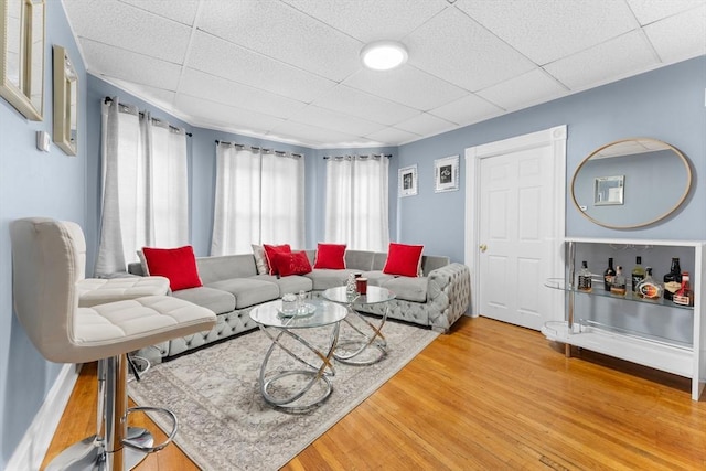 living room with hardwood / wood-style flooring, a paneled ceiling, and a wealth of natural light