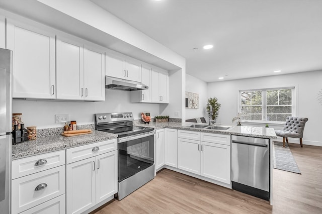 kitchen featuring stainless steel appliances, light stone countertops, light wood-type flooring, and white cabinetry