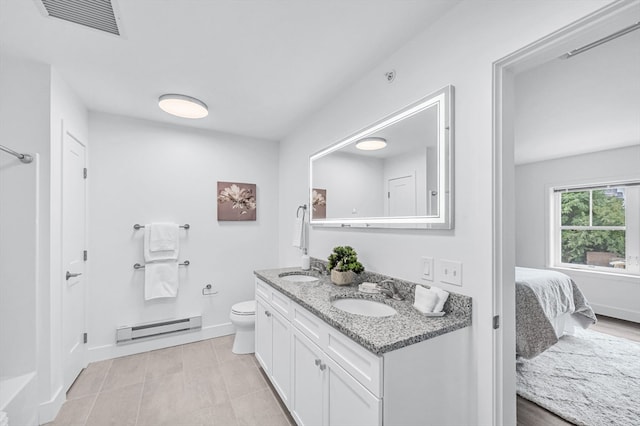 bathroom featuring a baseboard heating unit, vanity, and toilet