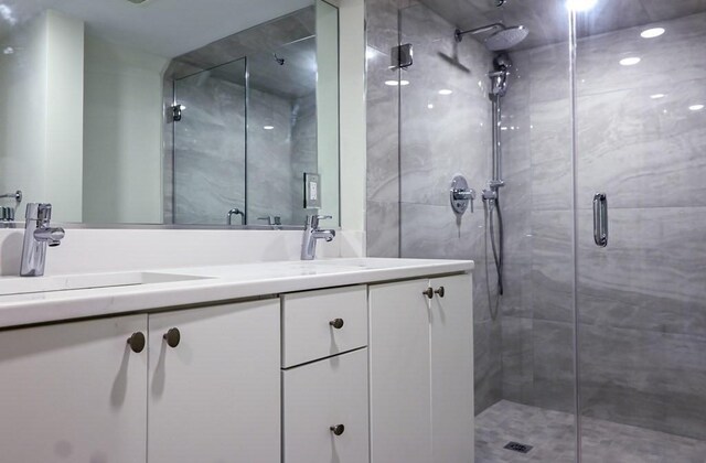 bathroom with vanity and a shower with door