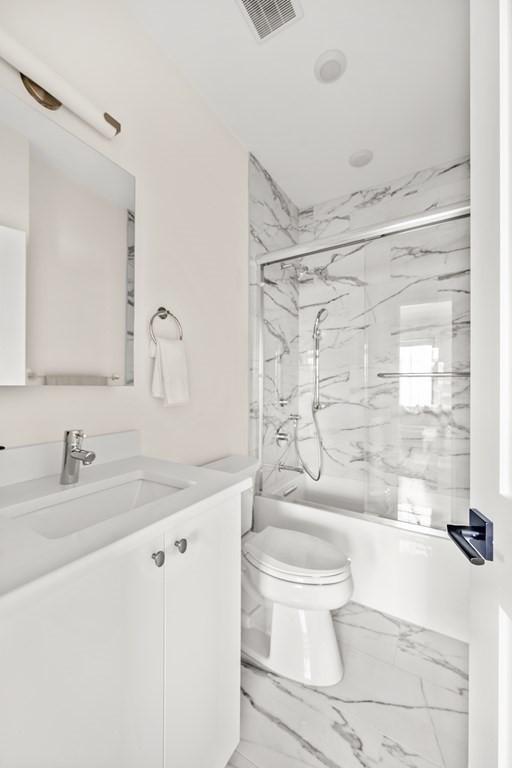 full bathroom featuring vanity, toilet, and enclosed tub / shower combo