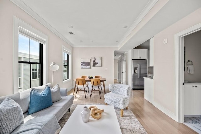 living room with light hardwood / wood-style flooring and crown molding