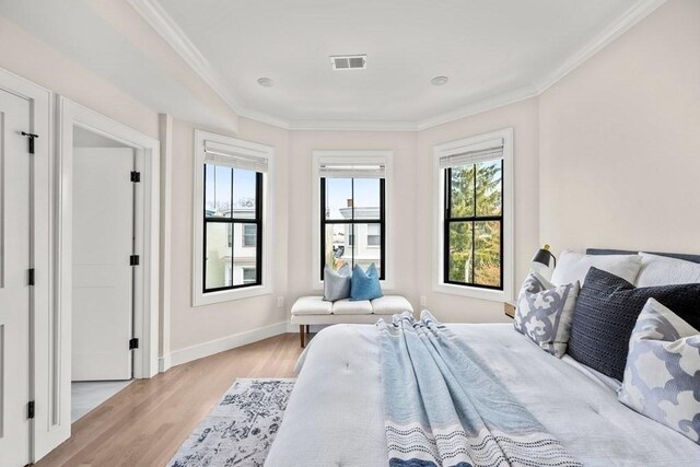 bedroom featuring light wood-type flooring and ornamental molding