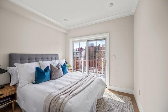 bedroom featuring access to exterior, hardwood / wood-style flooring, and crown molding