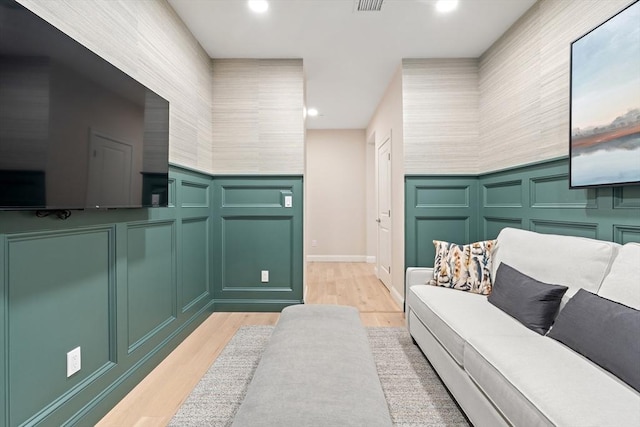 interior space with a decorative wall, recessed lighting, and wood finished floors