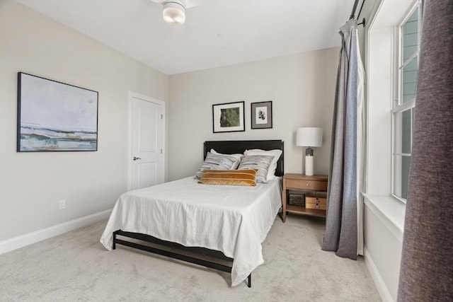 bedroom featuring baseboards and light colored carpet