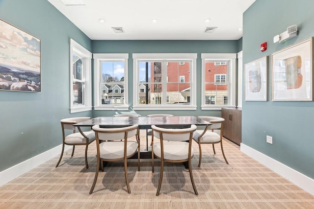 dining space featuring visible vents, baseboards, and light colored carpet