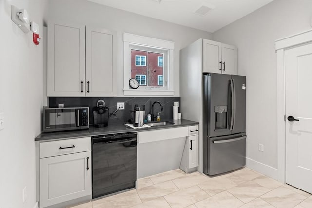 kitchen featuring refrigerator with ice dispenser, a sink, dark countertops, decorative backsplash, and dishwasher