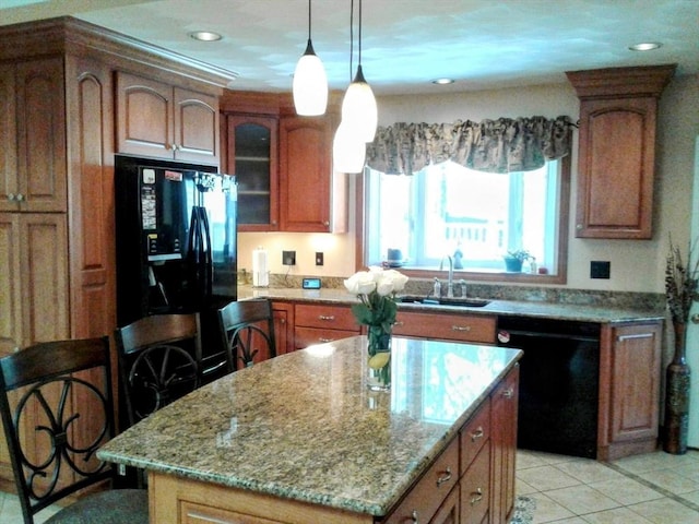 kitchen featuring black appliances, a sink, light stone countertops, a kitchen island, and glass insert cabinets