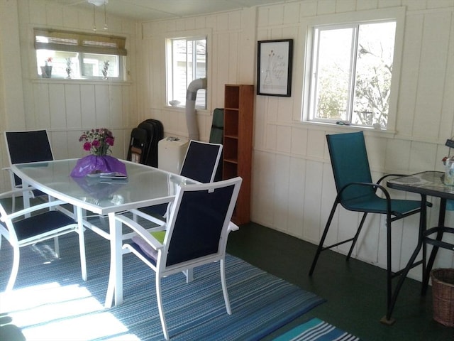 dining space featuring a decorative wall and plenty of natural light