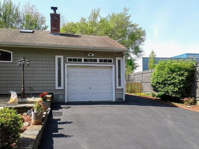 garage featuring fence and driveway