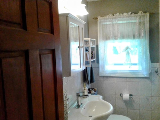 half bath with healthy amount of natural light, a sink, and toilet
