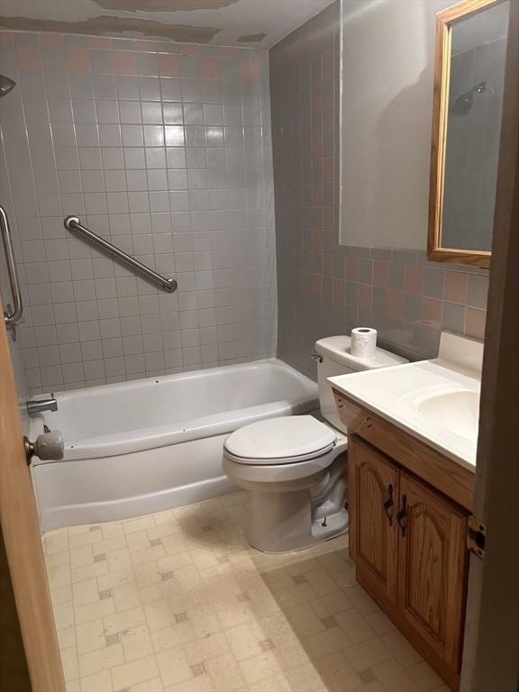 full bath featuring vanity, bathing tub / shower combination, toilet, tile walls, and tile patterned floors