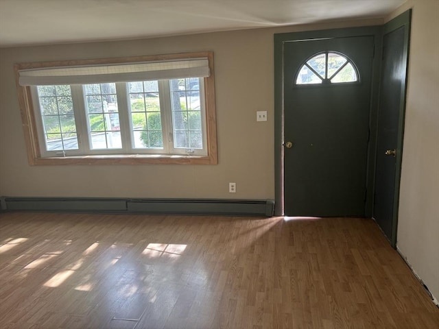 foyer featuring baseboard heating and wood finished floors