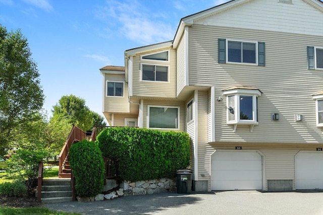 view of property featuring a garage and stairway
