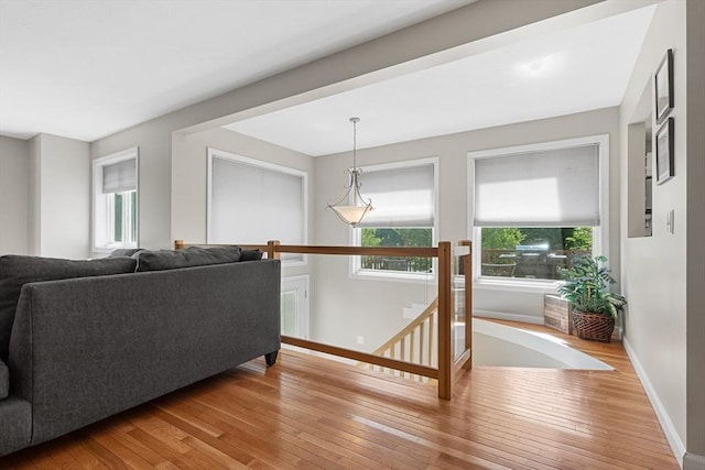living room featuring wood-type flooring, baseboards, and plenty of natural light