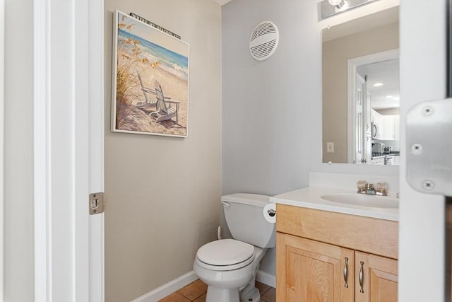 bathroom with vanity, tile patterned flooring, baseboards, and toilet