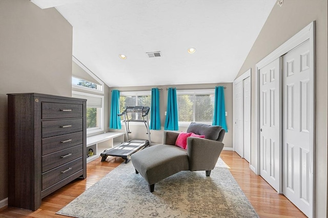 sitting room featuring visible vents, lofted ceiling, a wealth of natural light, and light wood-type flooring