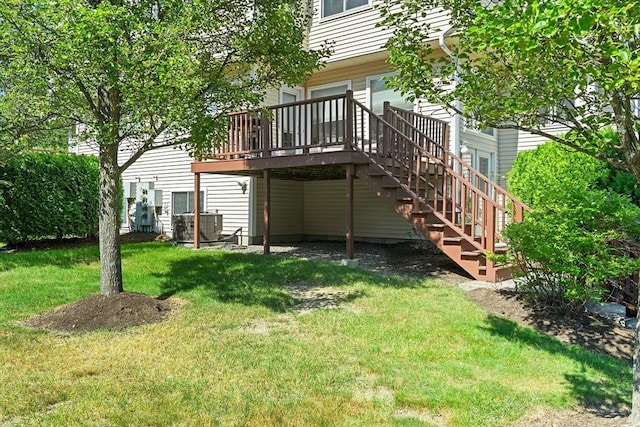 rear view of property featuring a lawn, a deck, and stairway
