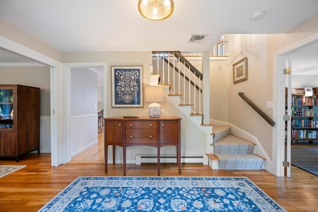 1051 Randolph Ave, Milton, MA 02186 - entryway with baseboard heating, wood finished floors, stairway, and a wainscoted wall