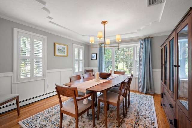 1051 Randolph Ave, Milton, MA 02186 - dining room featuring ornamental molding, baseboard heating, healthy amount of natural light, wainscoting, and light wood-style floors