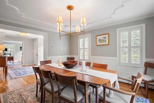 1051 Randolph Ave, Milton, MA 02186 - dining area with a chandelier, wood finished floors, a wainscoted wall, and ornamental molding