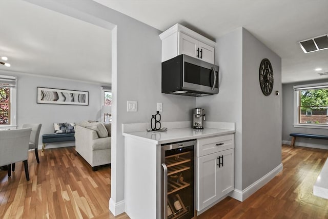 8 Longbow Cir, Lynnfield, MA 01940 - indoor dry bar featuring wine cooler, stainless steel microwave, light wood-style floors, baseboards, and recessed lighting