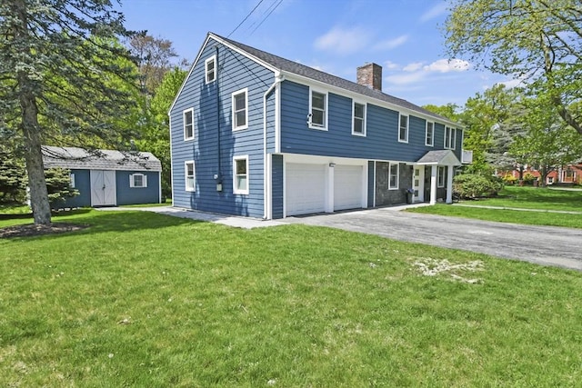8 Longbow Cir, Lynnfield, MA 01940 - view of front facade featuring a chimney, a garage, asphalt driveway, a front yard, and an outdoor structure
