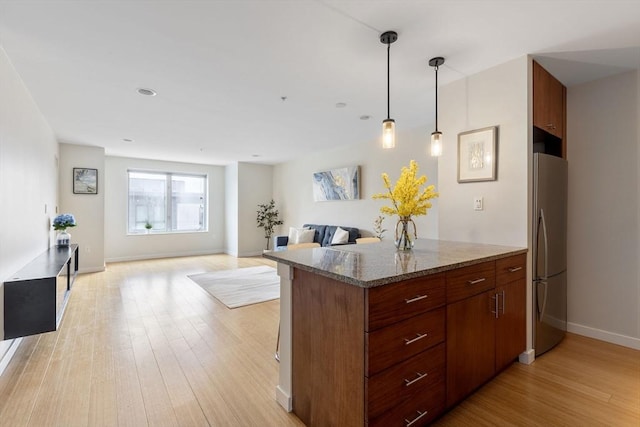 16 Miner St Unit 506, Boston, MA 02215 - kitchen featuring freestanding refrigerator, light wood finished floors, stone countertops, baseboards, and hanging light fixtures