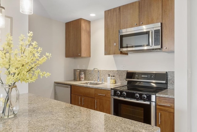 16 Miner St Unit 506, Boston, MA 02215 - kitchen featuring stainless steel appliances, a sink, brown cabinets, recessed lighting, and light stone countertops