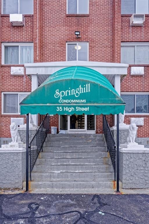 entrance to property featuring brick siding