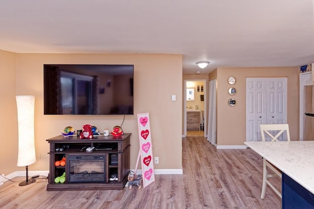 living area with baseboards and wood finished floors