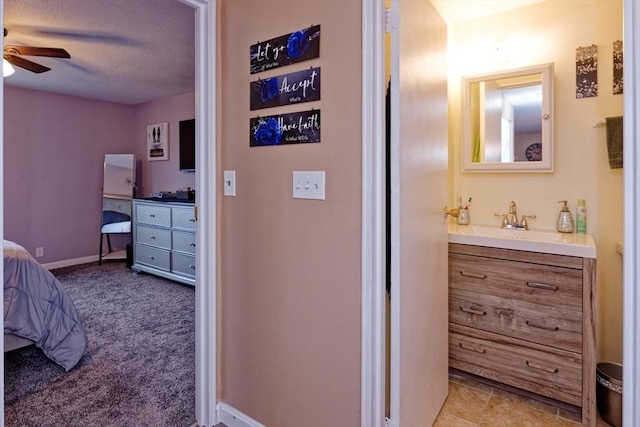 bathroom featuring a ceiling fan, connected bathroom, vanity, and baseboards