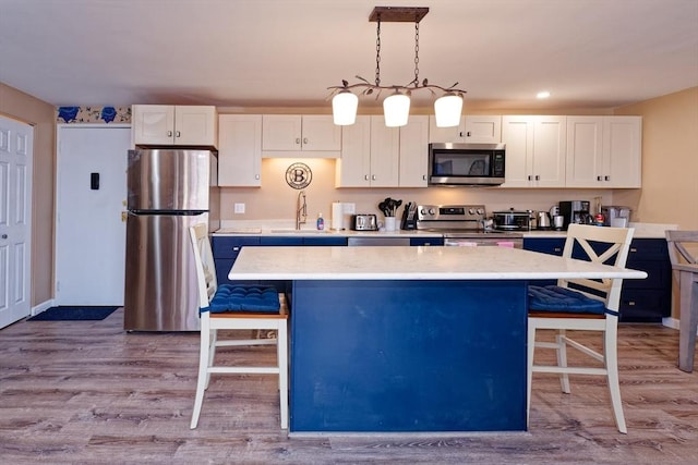 kitchen featuring a breakfast bar area, stainless steel appliances, a sink, and a center island