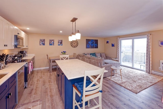 kitchen featuring blue cabinets, light wood finished floors, and stainless steel appliances